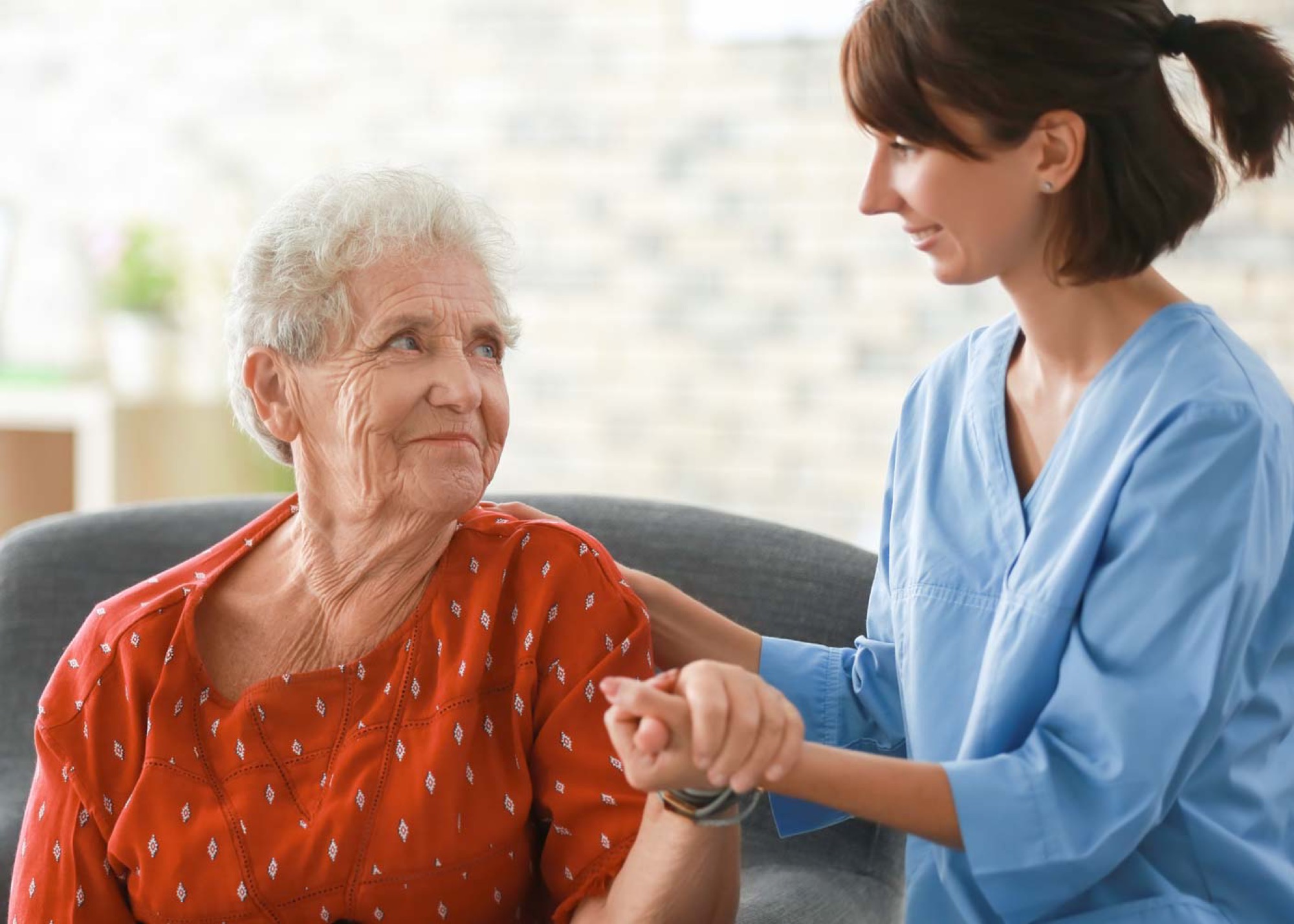 A caregiver offering comfort to an older woman